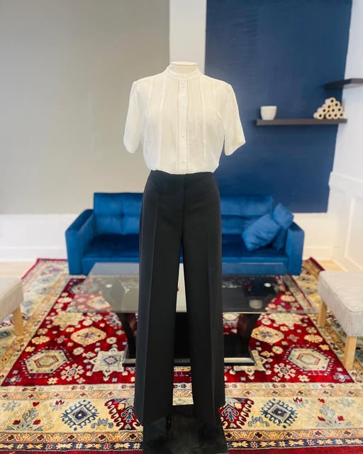 Cream blouse and tailored black trousers on a dress form