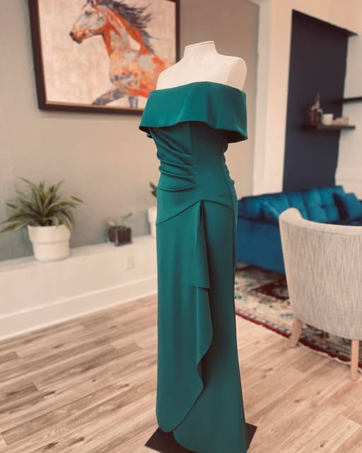 Emerald green off-the-shoulder gown fitted on a dress form