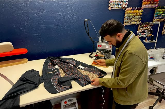 Noori working on a garment at the pressing table